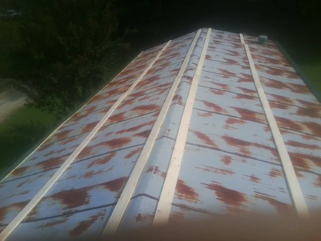 Rusted metal roof panels with new wood purlins before replacement — Storm Damage Roof Repair in Amazonia by Roofing Brothers