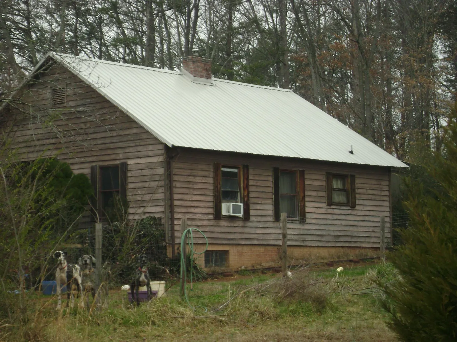 White metal roof on an old wood sided farmhouse, from a Metal Roof Installation job in Amazonia